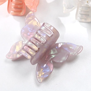 Detailed macro shot of iridescent purple double-layer butterfly hair claw with pearl finish