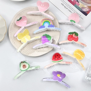 Colorful acrylic hair claw clips set with fruit and heart patterns on ceramic plate