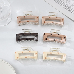 Detail view of six geometric tortoise dot hair claws in elegant neutral earth tones