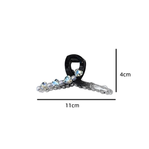 Detail view of crystal heart hair claw clip in gradient black and clear acrylic finish