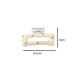 Detail view of cream hair claw clip with brown polka dots and 8.5cm measurement scale