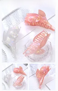 Détails rapprochés des pinces à cheveux papillon irisées en couleurs rose et blanc nacré