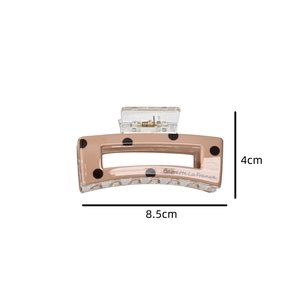 Detail of a beige acetate hair claw clip with black polka dots, sized 8.5cm by 4cm