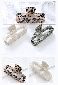 Detailed shot of large acetate square hair claws in tortoiseshell and polka dot patterns