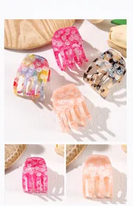 Detailed view of smiley face hair claw clips in colorful acetate and marble patterns