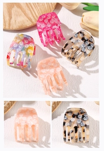 Detailed macro view showing diverse smiley face acetate hair claw clips with glossy texture