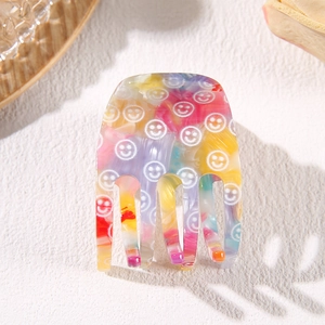Colorful marble acetate hair claw clip with white smiley face patterns and unique shadow