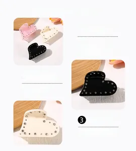 Detail view of acetate heart hair claw clips with rhinestones in pink, beige, and black