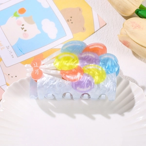 Pastel acrylic hair claw clip with colorful balloon beads and pink bow on white tray