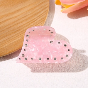 Pink heart-shaped acetate hair claw clip with rhinestones and marble texture