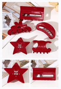Detail view of red acetate hair clips with golden logo and vintage shark clip patterns