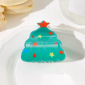 Festive Christmas tree hair claw clip with colorful star decorations on white plate