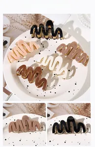 Detail view of acetate wave hair claws in five neutral colors with gold metal springs