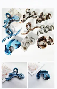 Detail of premium acetate hair claws showing marble texture and metal spring mechanism