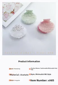 Detail of three shell-shaped acetate hair clips with sparkling rhinestones in soft pastel colors