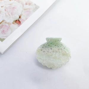 Sparkling shell-shaped acetate hair claw with white rhinestones in light green gradient