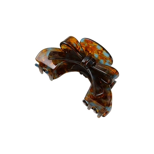 Detailed close-up of a handmade acetate bow hair claw clip with tortoise shell pattern