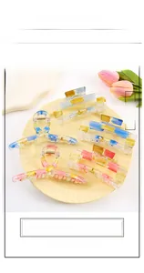 Close-up of assorted resin hair claws with colorful checkered patterns in a display tray