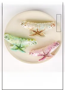 Detailed view of oversized starfish hair claws with marble texture and rhinestones