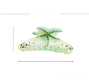 Close-up of a large starfish hair claw clip with green rhinestones and size markings