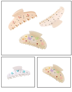 Detail showing acetate hair claws with colorful butterfly patterns and small rhinestones