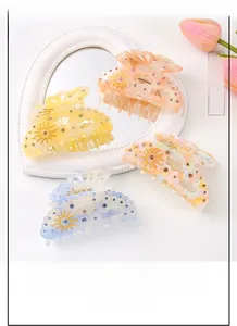 Detailed view of large acetate hair clips with sun pattern and inlaid rhinestones