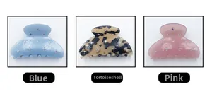 Detail view of acetate hair claws in blue, tortoiseshell, and pink with rhinestone studs