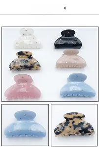 Detail of star-patterned rhinestone hair claws in six colors with resin finish