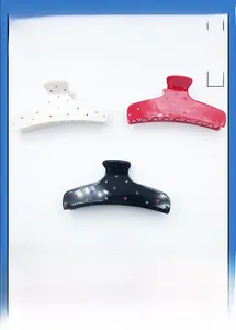 Close-up of set of three acetate hair claws with colorful rhinestones in white, red and black