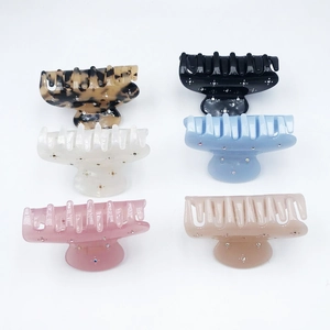 Set of 6 colorful acetate hair claws with sparkling rhinestones in a flat lay view