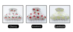 Detailed views of fruit print hair claws featuring cherry strawberry and lemon patterns
