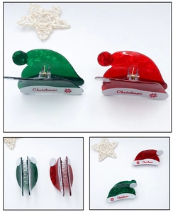 Detailed close-up of marble texture Christmas hat hair clips in red and green colors