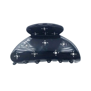 Elegant black acetate hair claw clip with sparkling star rhinestones on white background