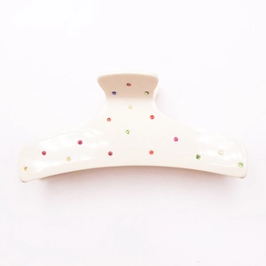 White acetate hair claw clip with colorful rhinestones in a curved shark clip design