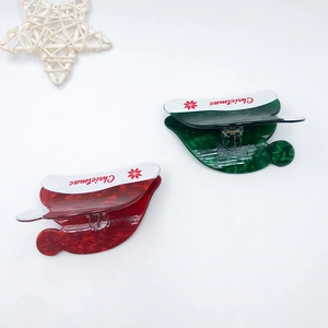 Christmas hat style PVC hair claw clips in red and green with festive snowflake patterns