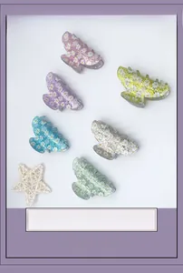 Detail view of six colorful acrylic hair claws with daisy patterns and shiny sequins