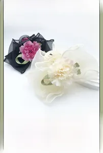 Detailed macro view of big mesh flower hair clips with elegant pearl accents and ribbons