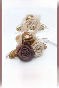Detail of elegant chiffon rose hair claw clip with stylish amber tortoiseshell texture