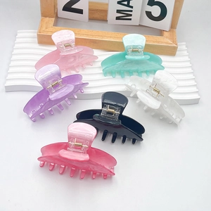 Classic acrylic hair claw clips in six colors with gold springs on white display stand