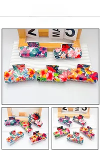 Detail shot of large PVC hair claws with colorful tropical floral patterns and multi-tooth design