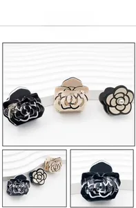 Detailed close-up of acrylic camellia hair clips with elegant pearl inlay and hollow design