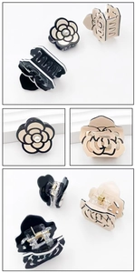 Close-up of camellia hair claw with pearl inlay and elegant black outlined petals