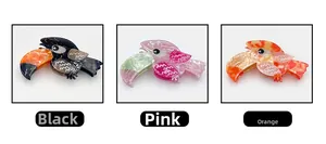 Detailed view of toucan-shaped acetate hair claws in black, pink, and orange colorways