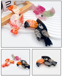Detailed macro view of acetate toucan hair claw with colorful marble texture pattern