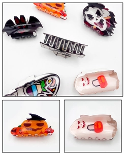 Detail of Halloween acrylic hair claws with pumpkin, bat, and ghost festive designs