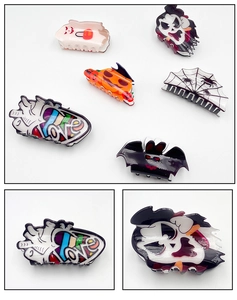 Detail of Halloween acrylic hair claws with spooky pumpkin bat and ghost patterns