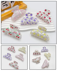 Close-up of translucent PVC fruit print hair claws with strawberry and cherry patterns