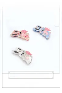 Detailed view of three large acetate rabbit hair clips with floral patterns and pink bows