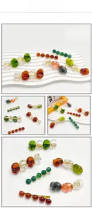 Macro shot of colorful irregular amber resin beads on golden metal duckbill hair clips