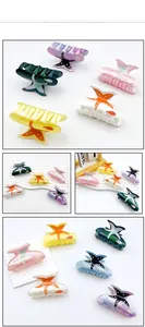 Detail view of starfish shaped acrylic hair claws with fish print in various colors